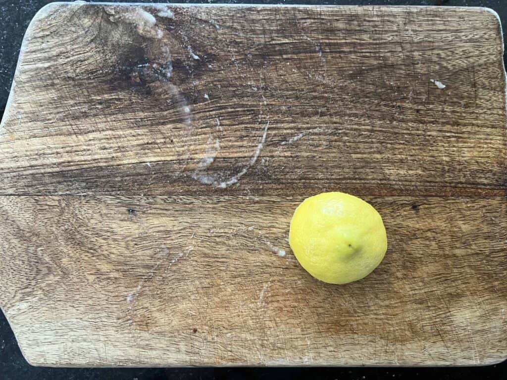 cleaning a wood cutting board with lemon and salt