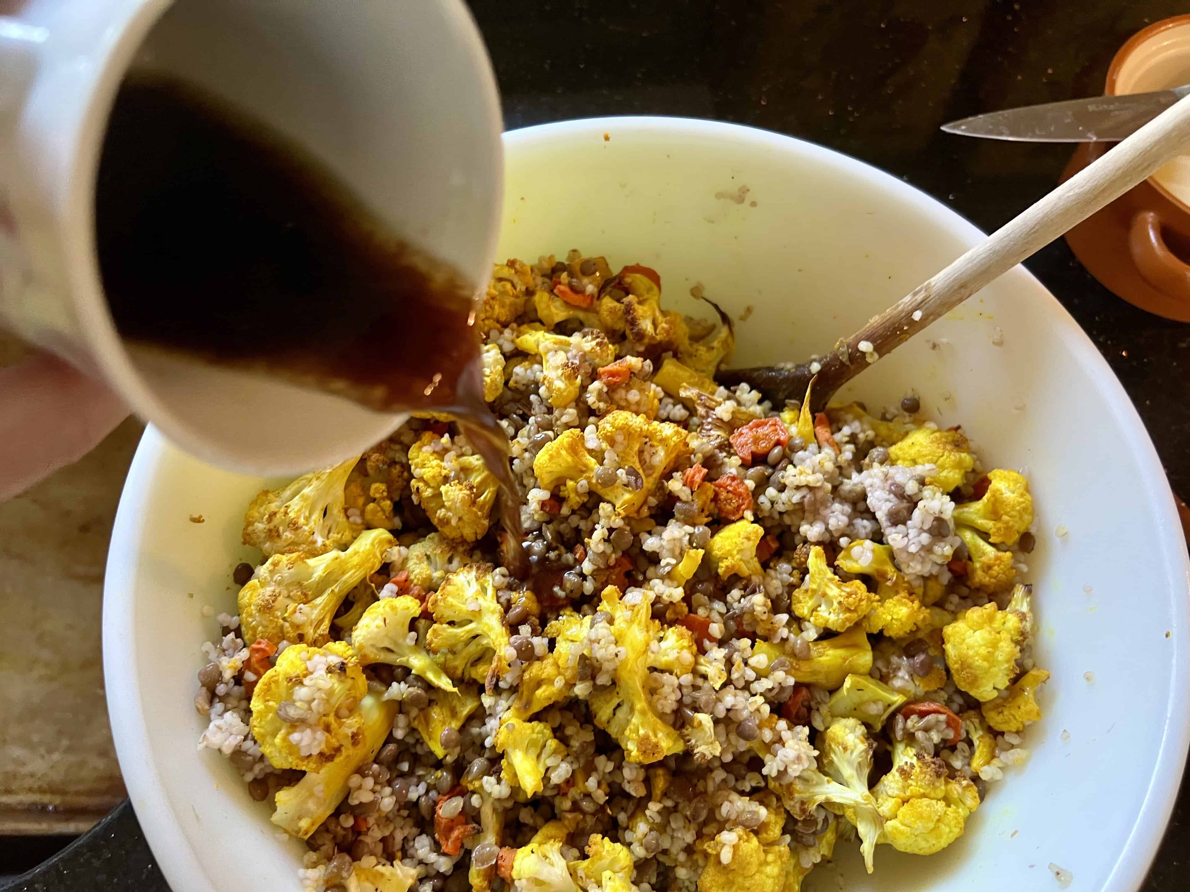 Pouring salad dressing over lentil salad