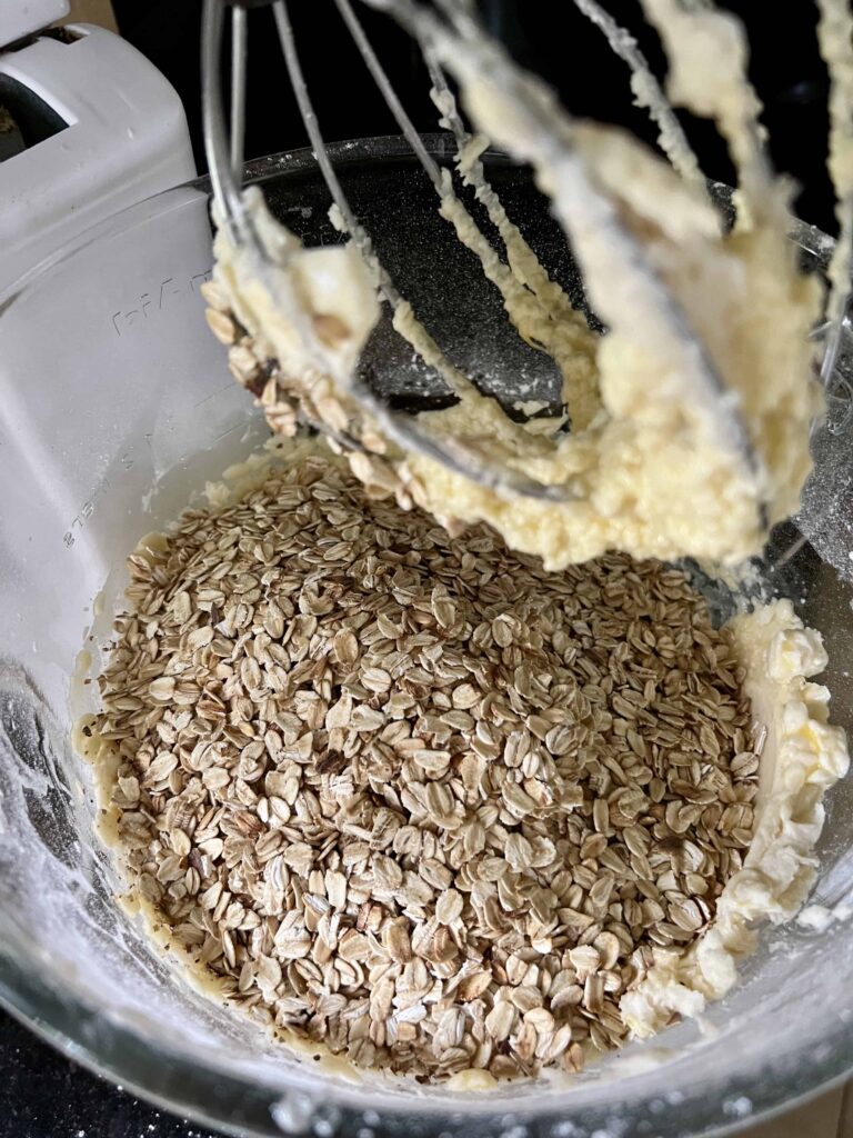 Adding the toasted oats to the mixing bowl