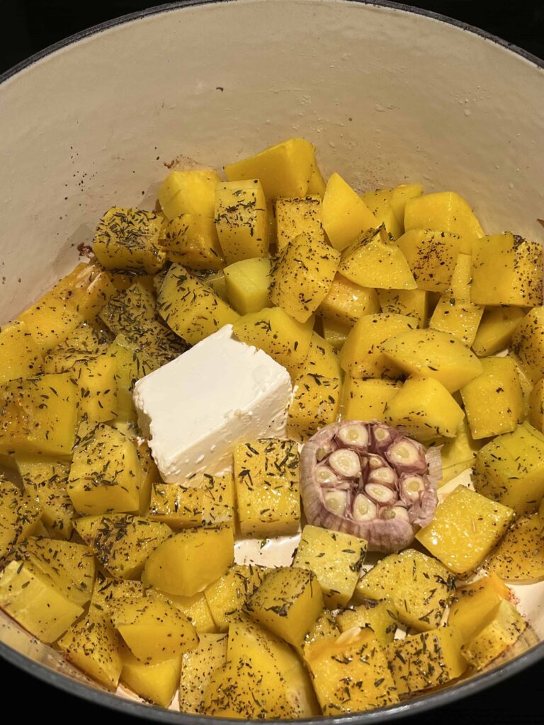 Roasted butternut squash, garlic, and feta cheese in a pot